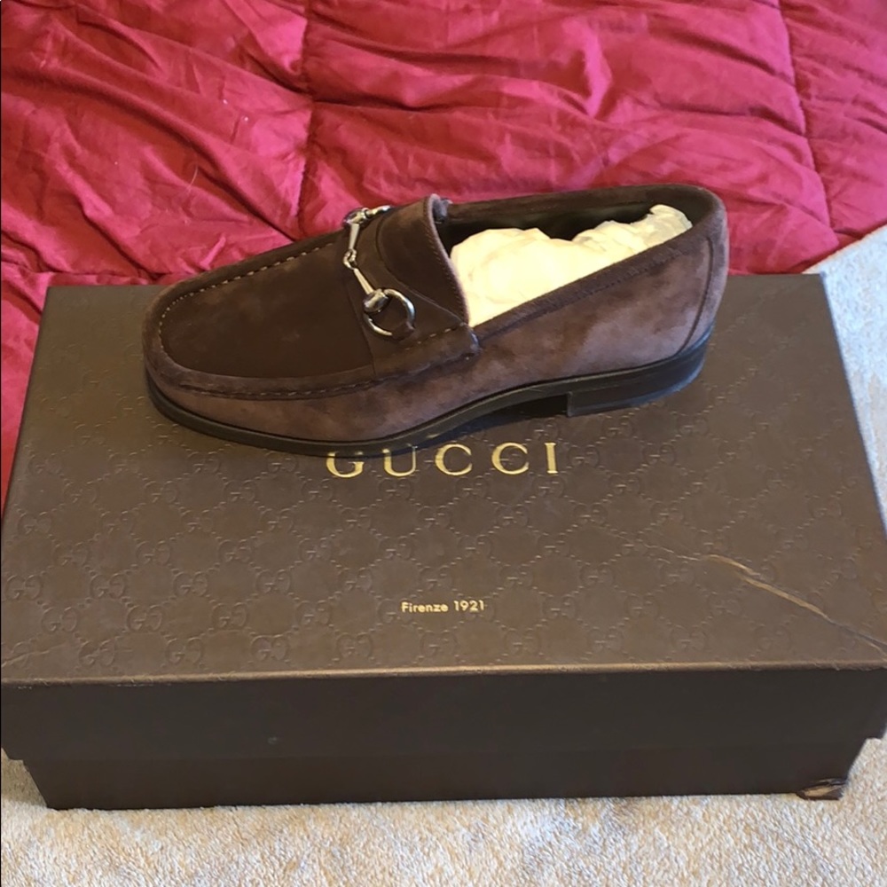 Brown Gucci loafers with silver clasps.